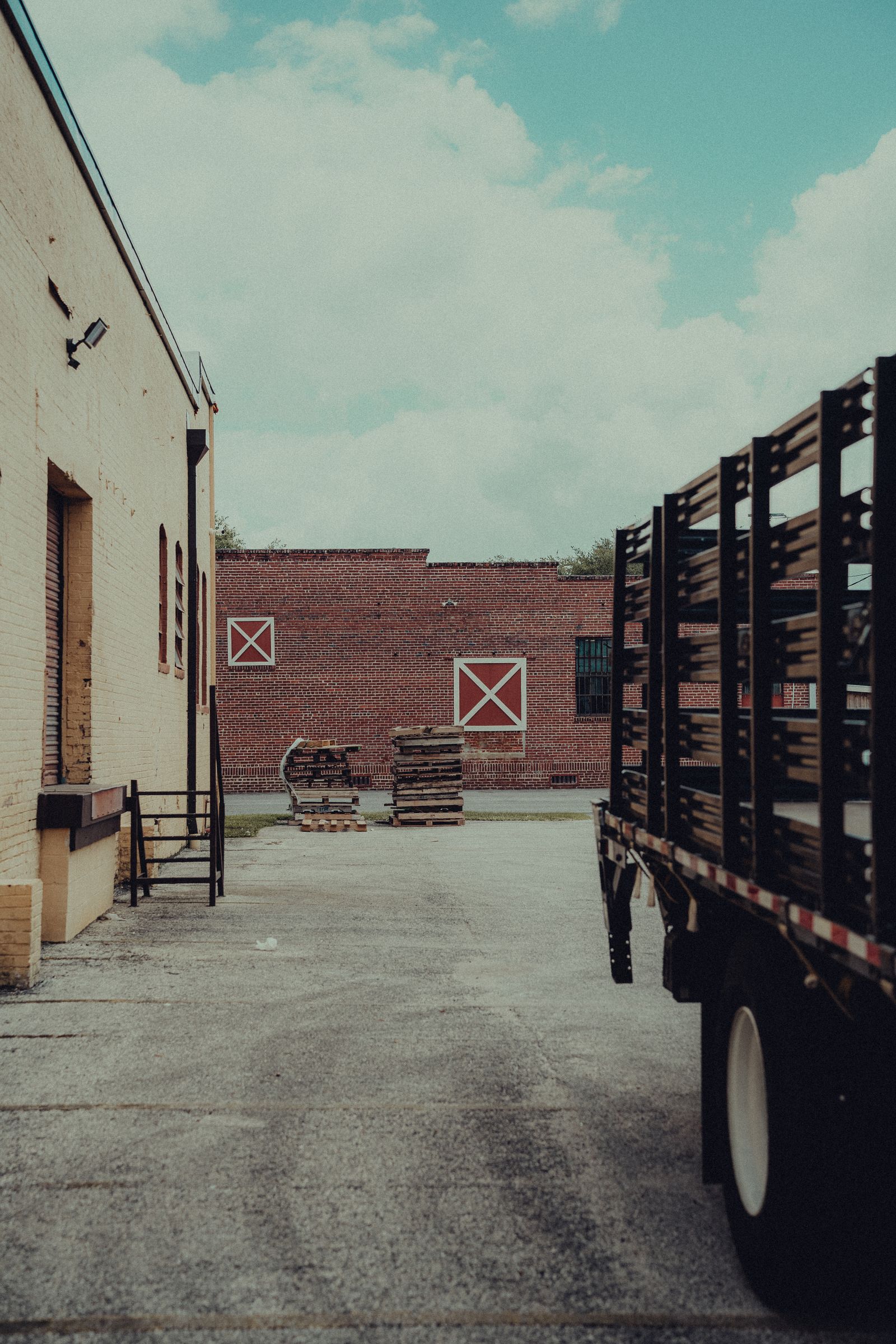 Transport truck and pallets in an industrial warehouse yard